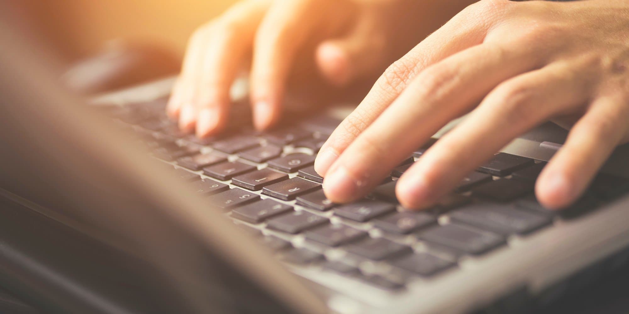 hands typing on laptop