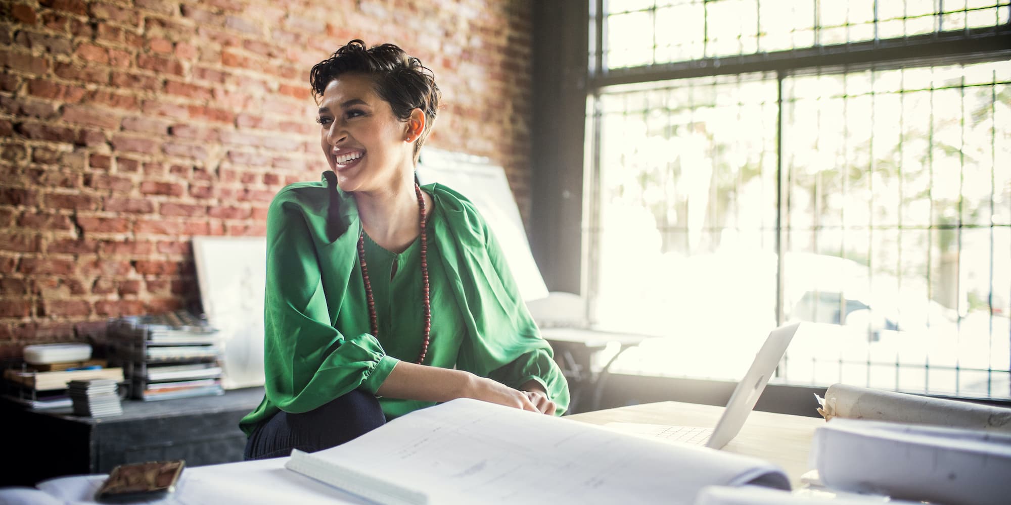 person sitting at table in office in front of laptop