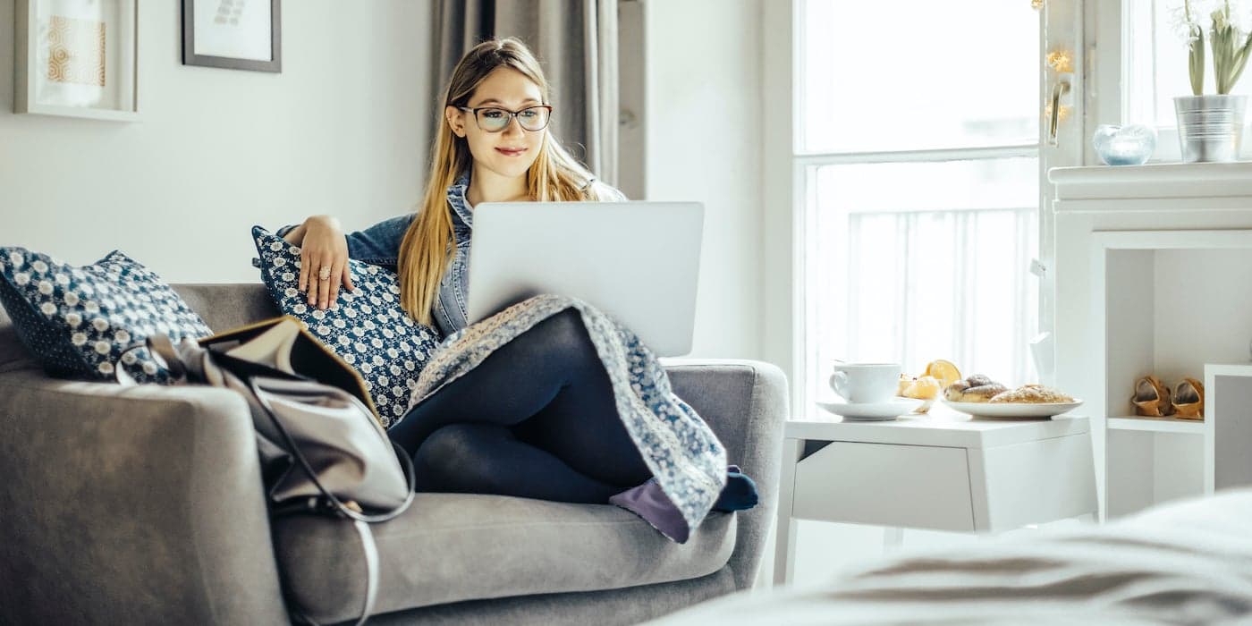 person sitting on a couch with a computer in their lap