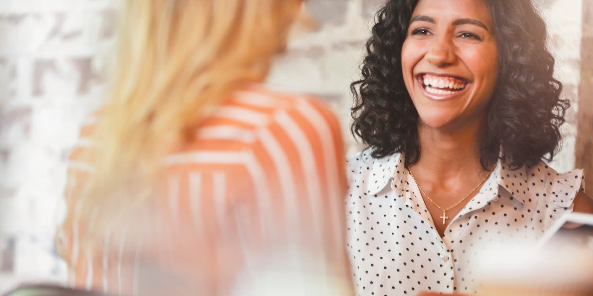 two people talking at a job interview, one person smiling and facing the camera