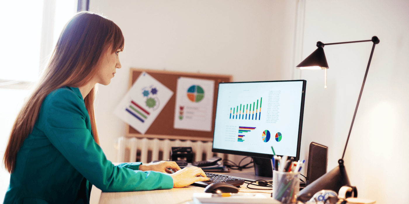 person sitting in front of computer looking at charts on the screen
