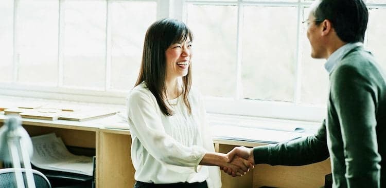 people shaking hands in office