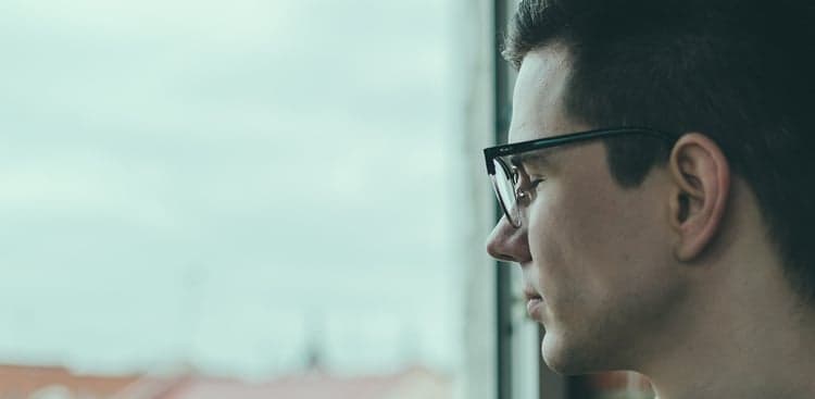 sad man looking out window