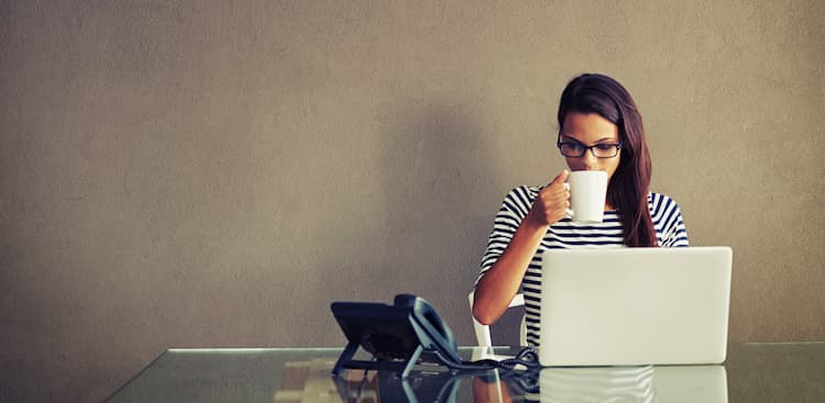 person drinking coffee at laptop