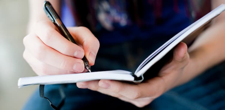 person writing in journal