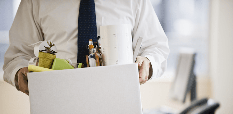 person carrying a box of belongings from their office