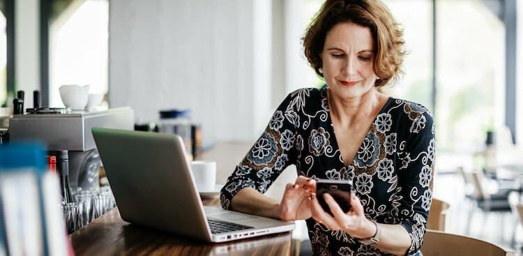 person on phone and laptop