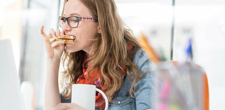 person eating breakfast at desk