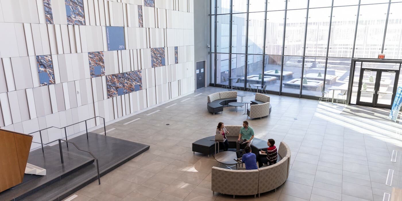 Four employees sitting around a coffee table at an office lobby