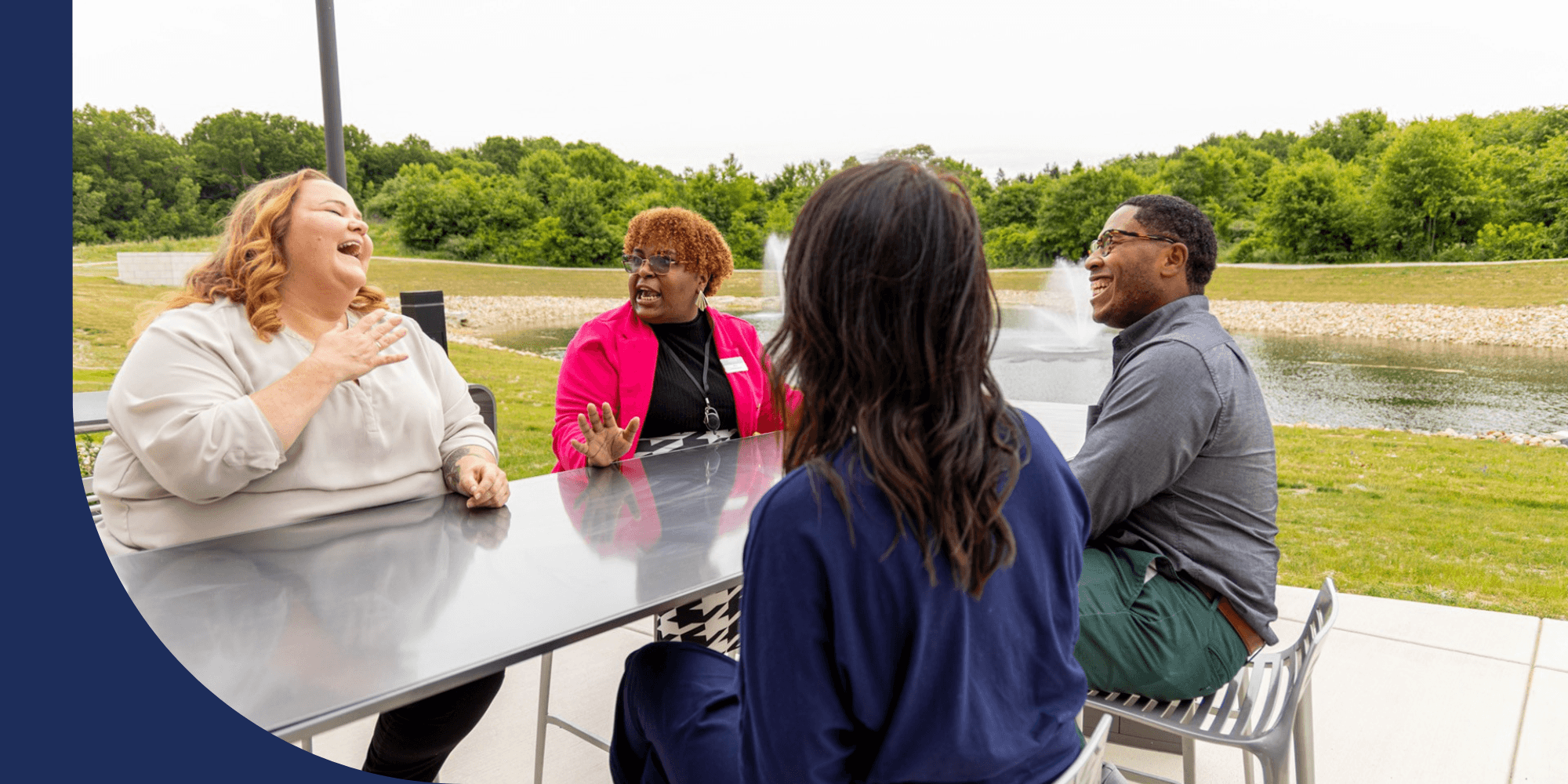 Four Advia Credit Union employees sitting at a table in an outdoor setting.