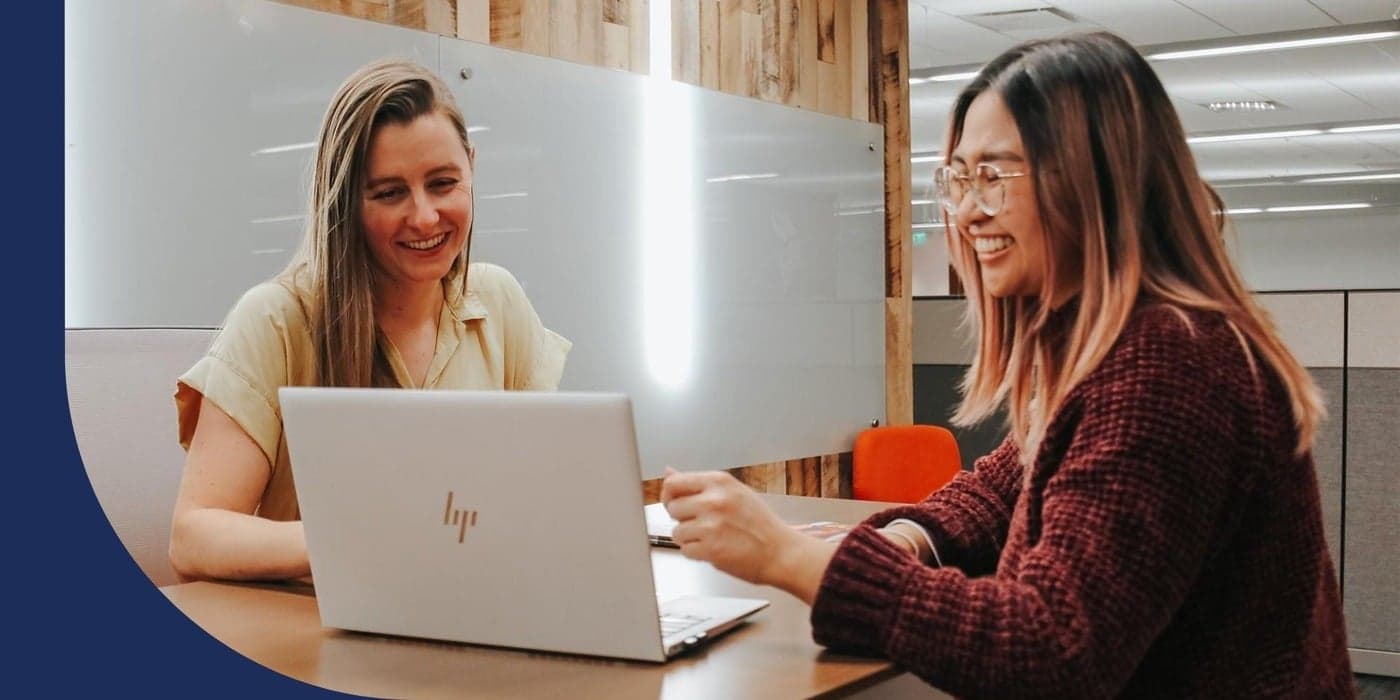 Two General Motors employees looking over a laptop together.