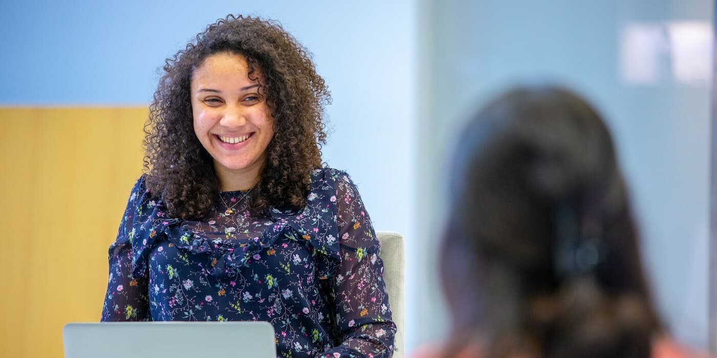 person with curly hair smiling