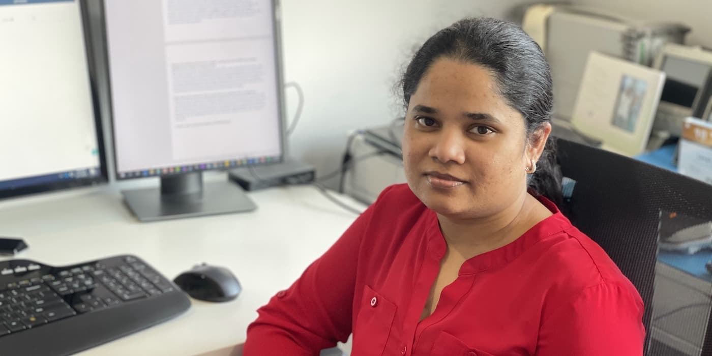 person in red shirt sitting in a home office