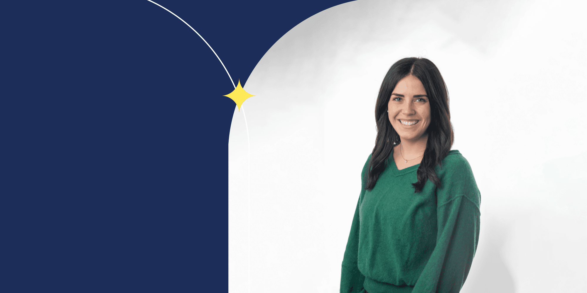 A smiling person with long brown hair dressed in a green sweater and facing the camera.