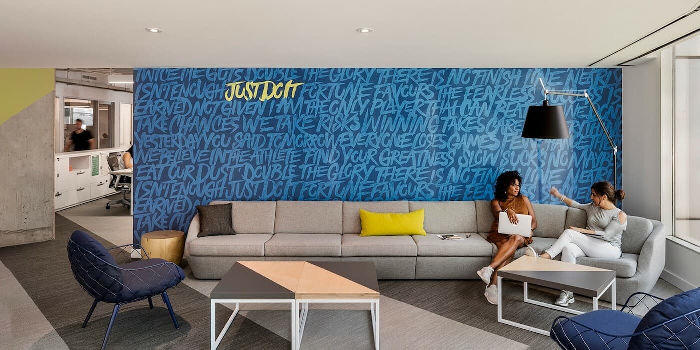 employees talking on a large couch in an office