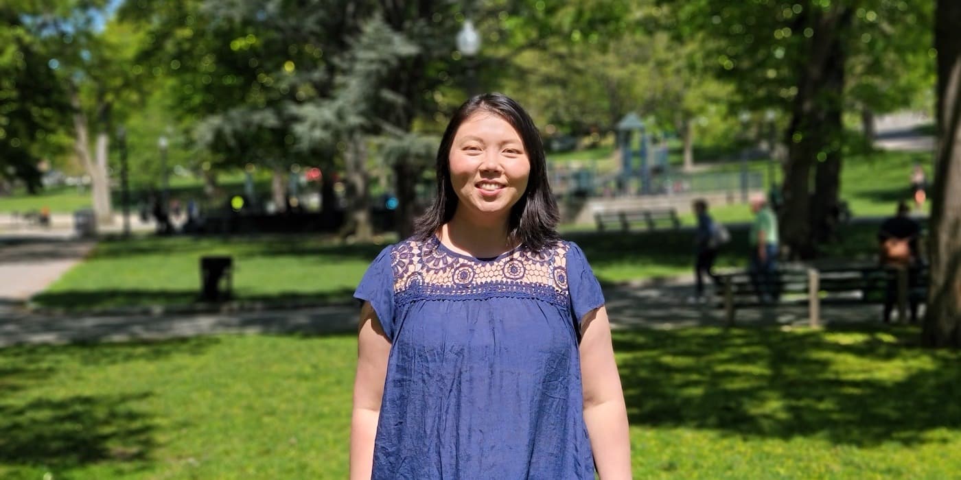person in a purple blouse standing in a park