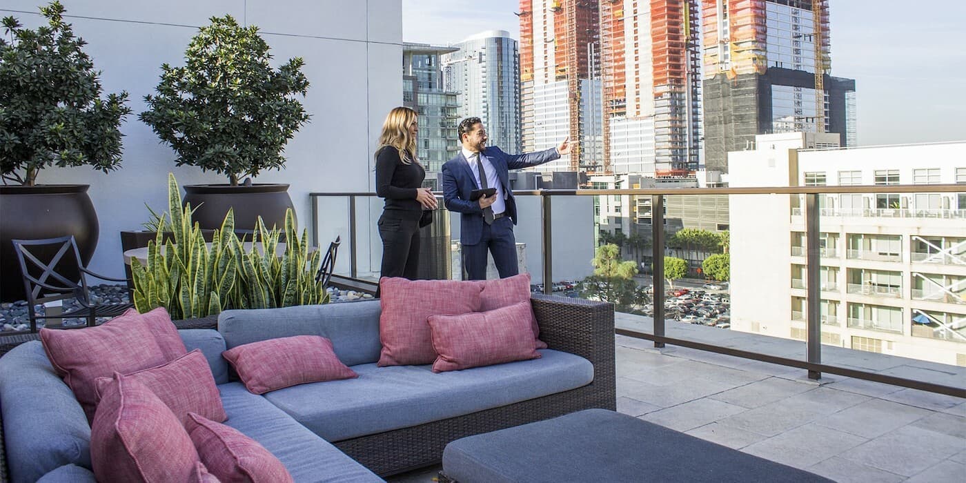 two people standing on a balcony terrace