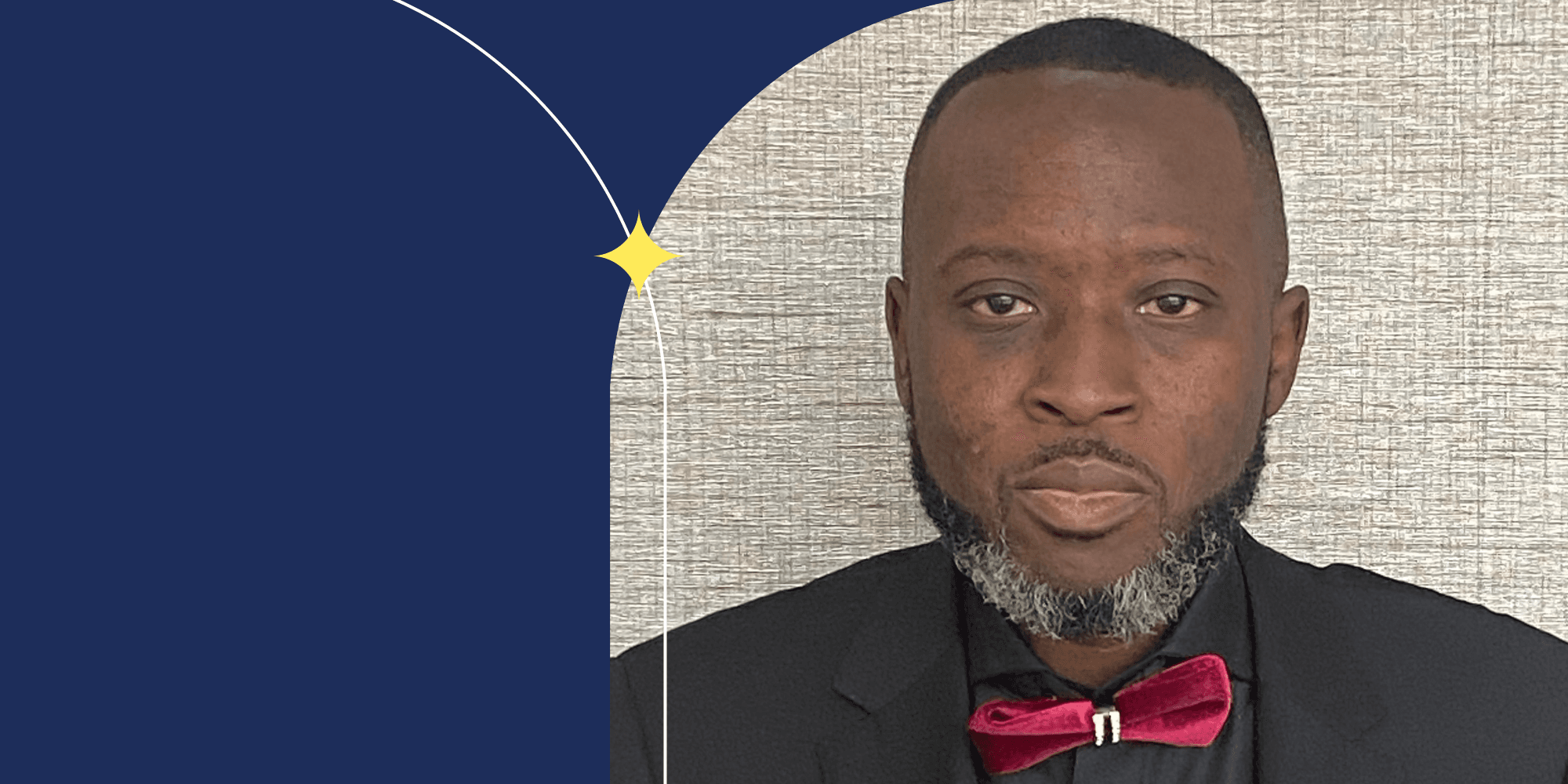 A person facing the camera. They have short hair, a beard, and and are wearing a red velvet bow tie.