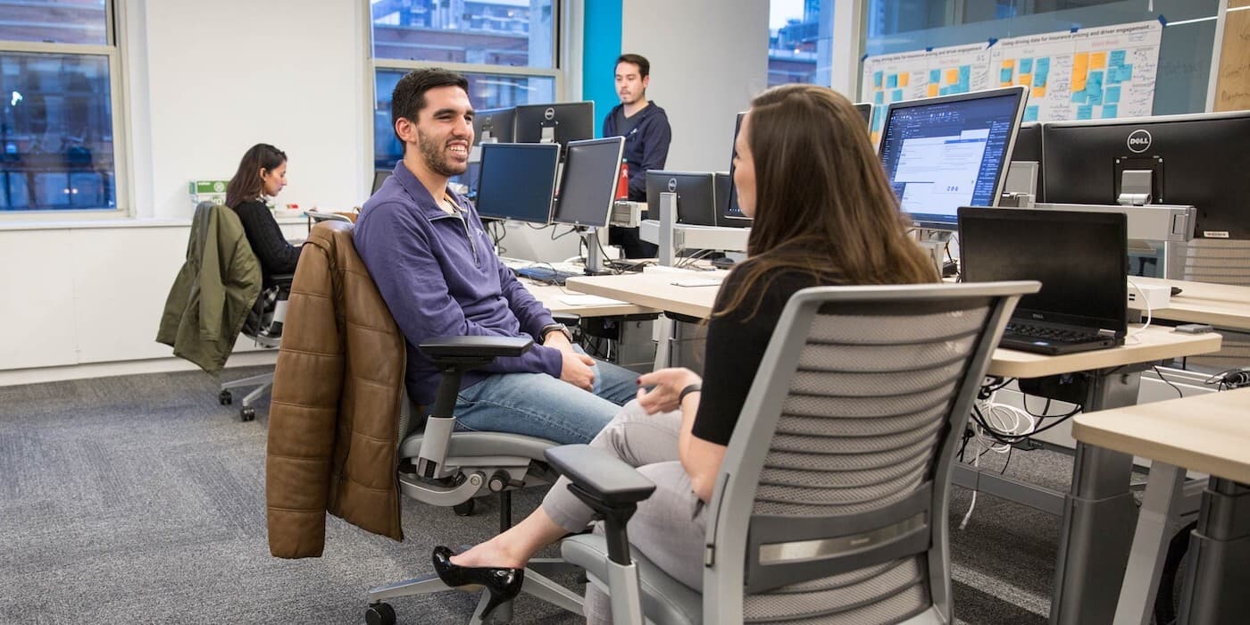 people talking by their desks in an office